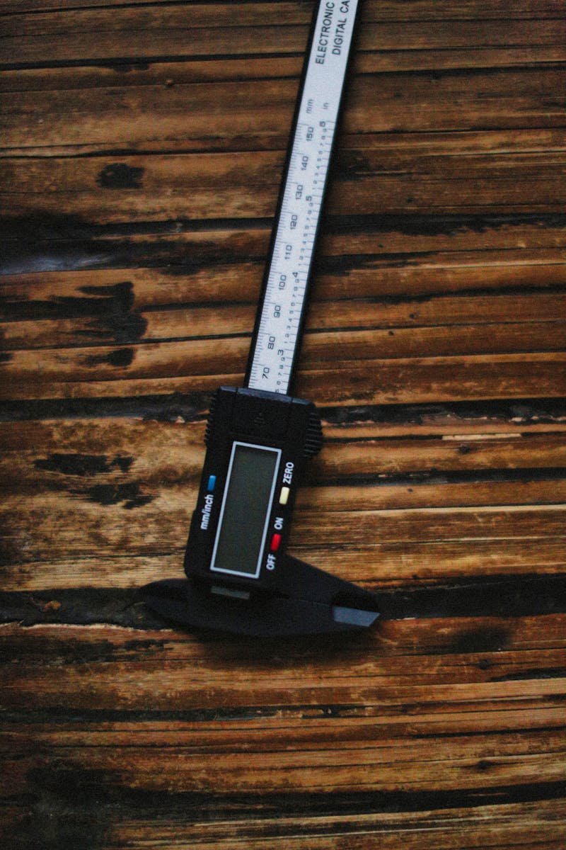 Close-up of a digital caliper on a wooden surface, emphasizing precision measurement.